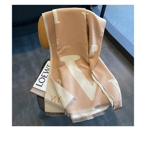 Détails de la texture de l'écharpe pashmina beige avec lettres et bords frangés
