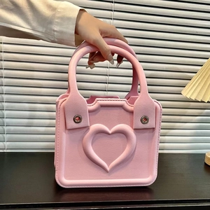 Detailed close-up of pink heart-embossed EVA handbag showing soft matte texture and handle