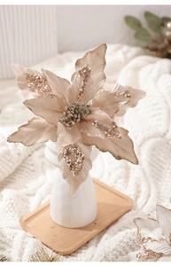 Gros plan d'un poinsettia en velours champagne avec paillettes dorées et pistil nacré