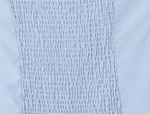 Close-up of blue and white striped fabric with elastic smocking detail and texture