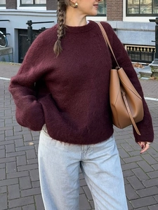 Street style shot of a burgundy fuzzy knit sweater with loose fit and crew neck design