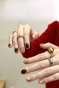 Detail of short round press-on nails in coffee cat-eye and champagne gold glitter finishes
