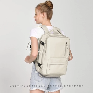 Model wearing a multifunctional cream travel backpack with multiple compartments and side straps