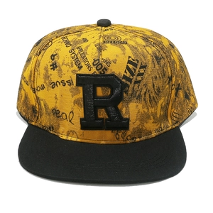 Détail de la lettre R en relief 3D sur une casquette hip-hop jaune avec motifs graffiti