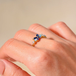 Close-up of gold 925 sterling silver ring with blue and white opal butterfly stones