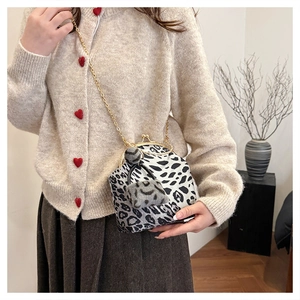 Leopard print shell bag with gold chain strap worn with a beige cardigan