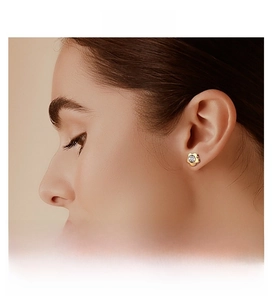 Detailed close-up of a golden five-petal flower stud earring with a central zircon
