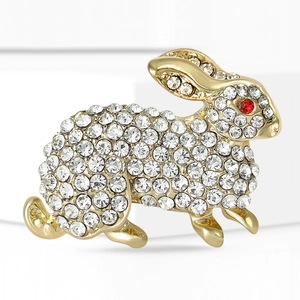 Close-up of cute rabbit brooch with clear crystals and red rhinestone eyes on gold base