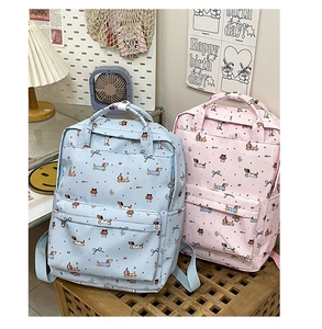 Detail of light blue and pink graffiti backpacks with cartoon dachshund and bow prints