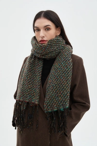 Close-up of thick woven multi-color scarf with fringe details worn by a model