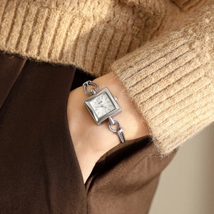 Silver square dial ladies watch with metallic woven bracelet strap on model wrist