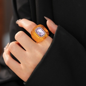 Détail macro d'une bague vintage en résine avec pierre violette et cristaux sur costume