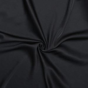 Détail de la texture fluide du tissu noir avec un drapé en spirale élégant et brillant