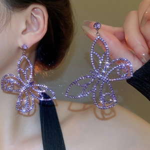 Macro detail of luxury purple zircon butterfly drop earring with sparkling crystal accents