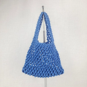 Detail of blue cotton woven beach bag showing intricate crochet hollow mesh pattern