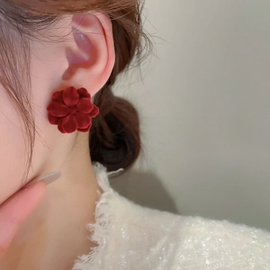 Close-up of a model wearing a vintage red flocked flower stud earring in a French style