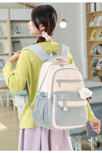 Detail of waterproof student backpack in pink and blue with a cute cloud charm