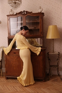 Close-up of yellow hollow-out knit set featuring intricate floral texture and flared sleeves
