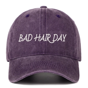 Détail de la broderie blanche BAD HAIR DAY sur une casquette vintage en coton lavé violet
