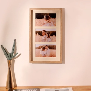Minimalist light wood triple photo frame in a shadow box style hanging on a warm wall