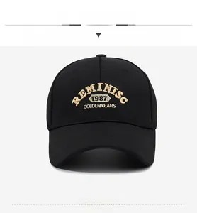 Detail of black cotton baseball cap featuring gold REMINISC 1987 embroidery texture