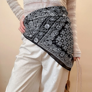 Polka dot pearl silk scarf worn as a retro stylish waist belt on white trousers