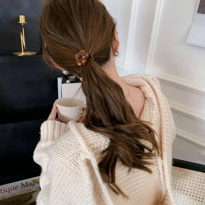 Amber flower hair tie on a ponytail, elegant floral accessory for minimalist hairstyles