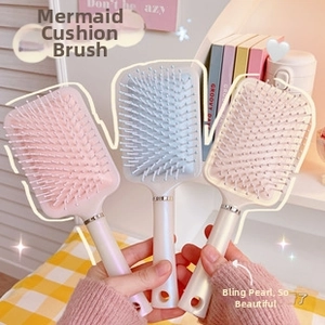 Close-up of pearlized finish air cushion massage combs with ergonomic round handles