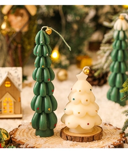 Detail of mini Christmas tree candles in green and white colors on snowy wooden base
