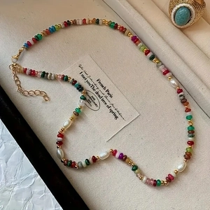 Detail of colorful beads and freshwater pearls on an adjustable gold clasp necklace