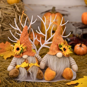 Detail of harvest gnomes with orange knit hats, sunflowers and autumn maple leaves