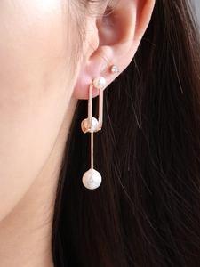 Detailed view of rose gold long drop pearl earrings with elegant zircon inlay on ear