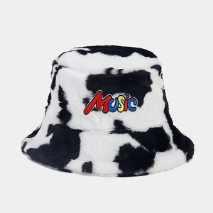 Close-up of fluffy cow print bucket hat with colorful Music embroidery and soft texture