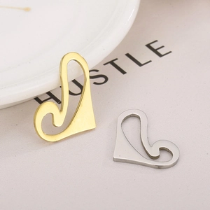 Minimalist hollow heart swan pendants in gold and silver finish on textured fabric
