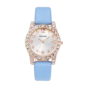 Dettaglio dell'orologio di lusso da donna con lunetta di cristalli e cinturino blu