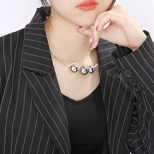 Close-up of a silver punk choker featuring three metallic beads on a female model