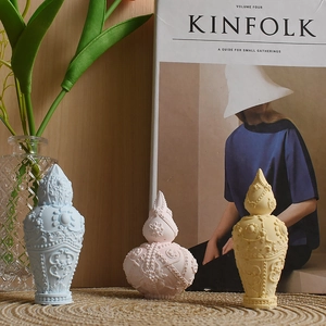 Detailed relief patterns on vintage-style bottles in pastel blue, pink, and yellow tones