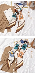 Detail of silk scarf with poker card print tied over a cozy beige sweater neck
