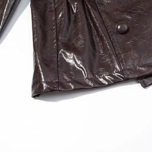Detailansicht des dunkelbraunen PU-Jackensaums mit präzisen Nähten und glänzendem Leder