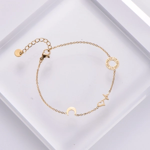 Gold stainless steel bracelet with heart moon and hollow round pendants on acrylic block