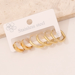 Detailed macro view of three pairs of gold stainless steel geometric hoop earrings