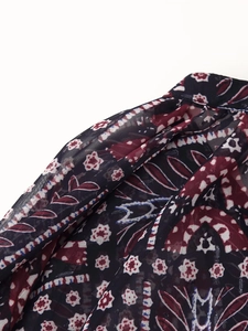Close-up of lightweight chiffon fabric with intricate red and blue paisley patterns