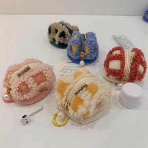 Macro detail of colorful waffle plush storage cases with pearls and metal zippers