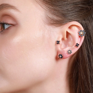 Classic gold flower and smiley face ear stud set with blue gems on a female model