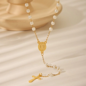 Cross pearl rosary necklace with gold Virgin Mary medal in elegant sunlight lighting