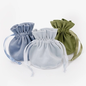 Three premium velvet drawstring gift bags in blue, light blue, and green with satin ribbons