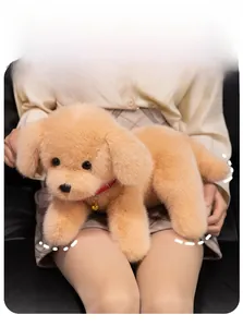 Close-up of golden plush puppy toy with fluffy fur, red collar and golden bell detail