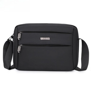 Front view of black nylon drawstring bag showing dual zipper pockets and adjustable strap