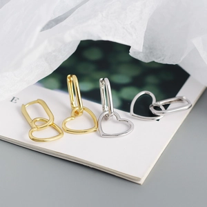 Close-up of gold and silver heart earrings with rectangular hoops on white card