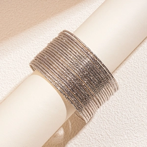 Dettaglio di 20 bracciali rigidi in metallo argento con trama diamantata lucida